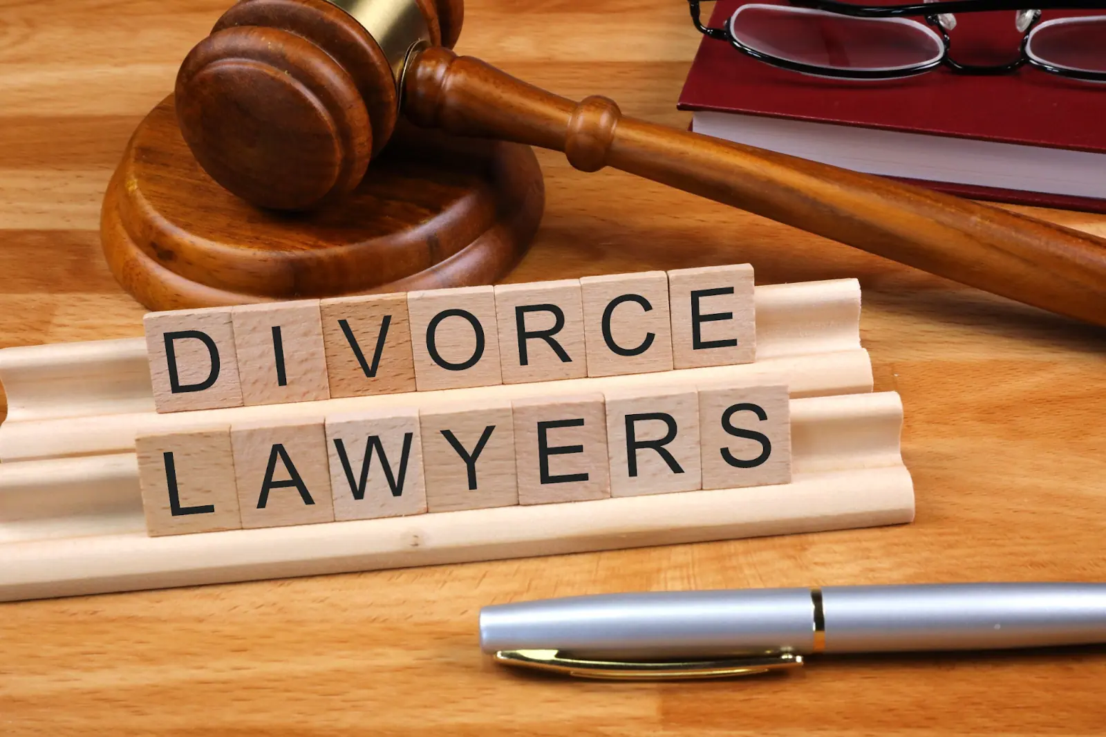 Wooden gavel beside blocks spelling divorce lawyers